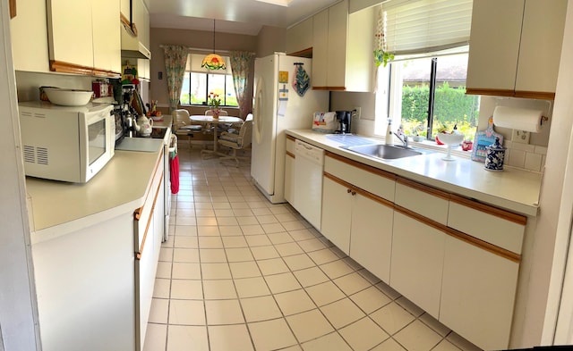 kitchen with plenty of natural light, white appliances, white cabinets, sink, and decorative light fixtures