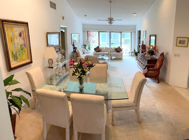 dining area with light carpet, ceiling fan, and lofted ceiling