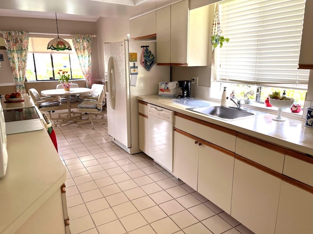 kitchen featuring white appliances, sink, light tile patterned floors, decorative light fixtures, and white cabinets