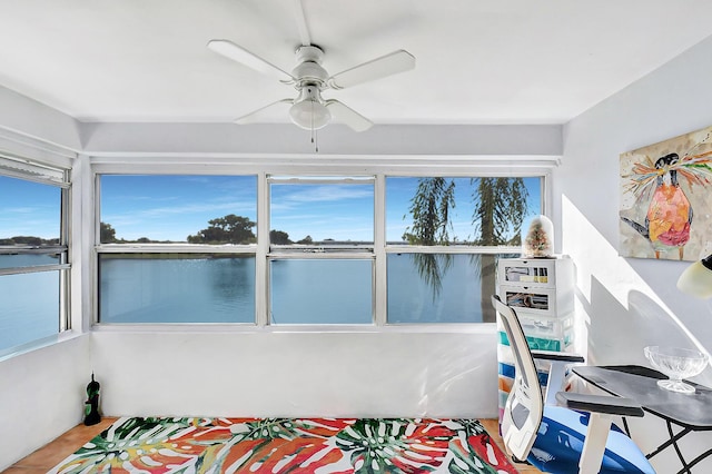 bedroom featuring a water view and ceiling fan