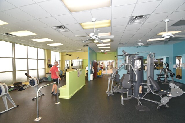 gym with a paneled ceiling and ceiling fan