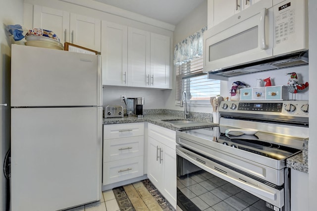 kitchen with light stone counters, white cabinets, light tile patterned flooring, and white appliances