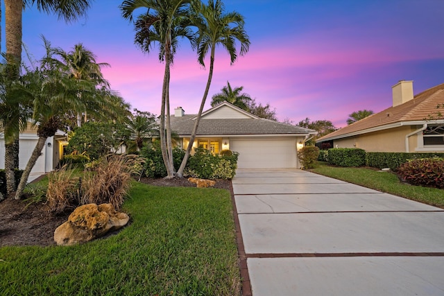 view of front of home featuring a garage and a yard