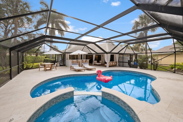 view of pool with a lanai, a patio, and an in ground hot tub