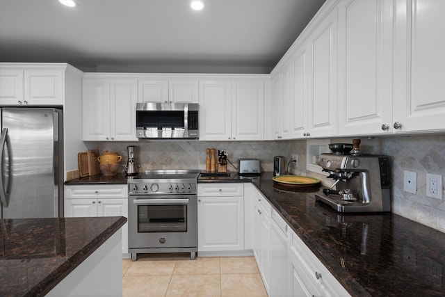 kitchen with stainless steel appliances, white cabinetry, and backsplash