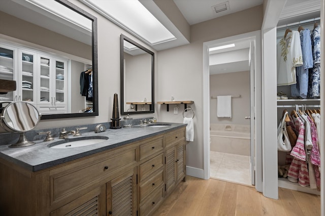 bathroom with hardwood / wood-style floors, vanity, and a bathing tub