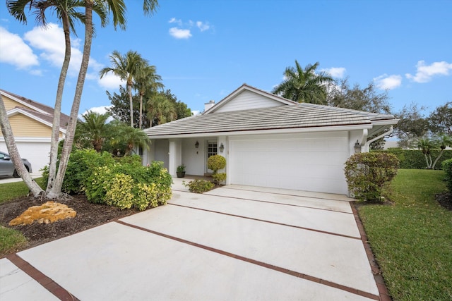 view of front of property featuring a front yard and a garage