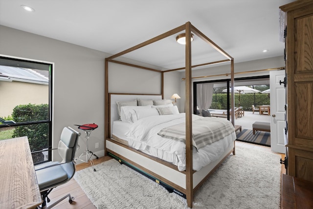 bedroom featuring light wood-type flooring, access to exterior, and multiple windows