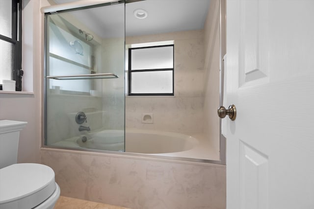 bathroom with enclosed tub / shower combo and toilet