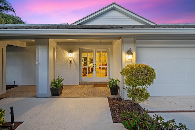 exterior entry at dusk with french doors and a garage