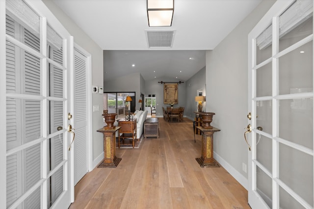 hall featuring light wood-type flooring and a barn door