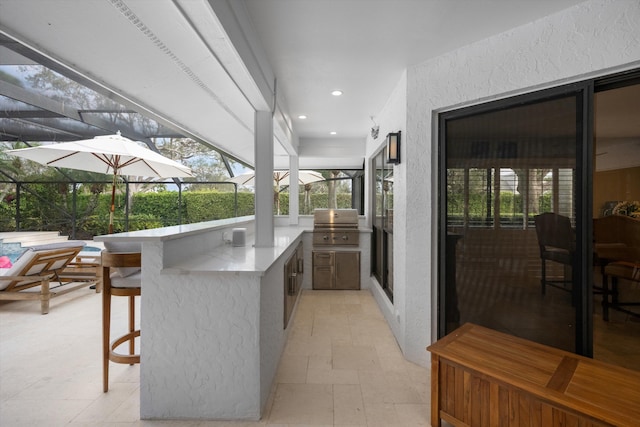 view of patio / terrace featuring area for grilling, exterior bar, glass enclosure, and exterior kitchen