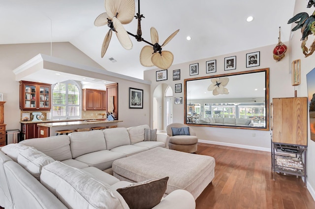 living room with ceiling fan, dark hardwood / wood-style flooring, a healthy amount of sunlight, and lofted ceiling