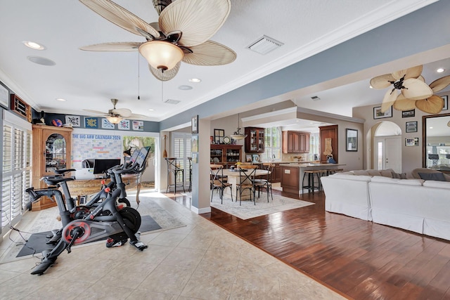 exercise room featuring light tile patterned floors and crown molding