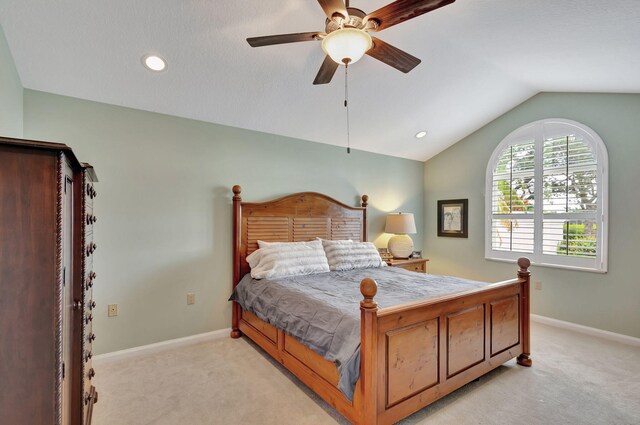 bedroom featuring light carpet, vaulted ceiling, and ceiling fan