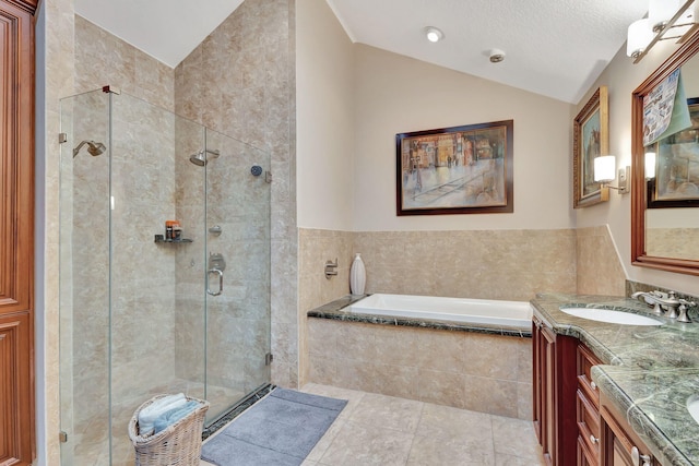 bathroom featuring tile patterned flooring, lofted ceiling, vanity, independent shower and bath, and tile walls