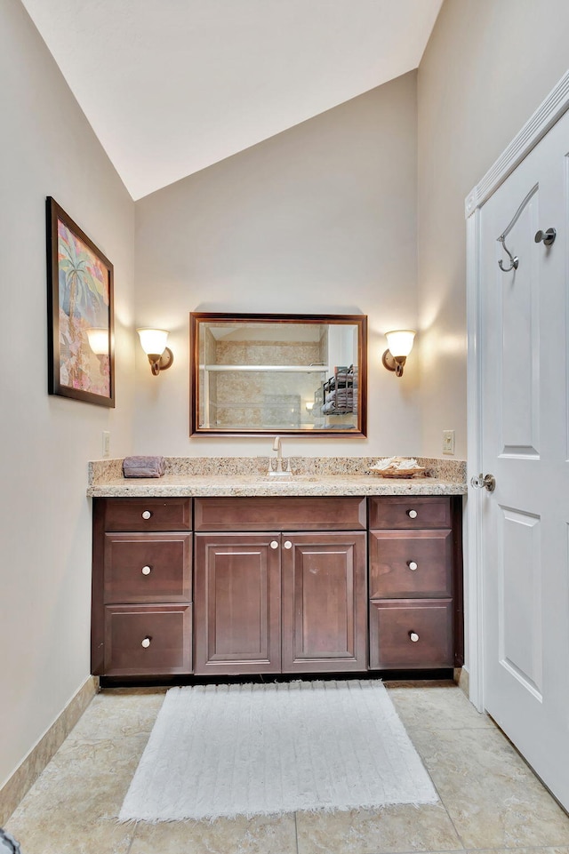 bathroom featuring a shower, vanity, and lofted ceiling