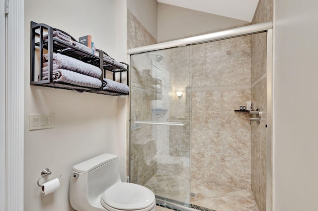 bathroom featuring toilet and a shower with door