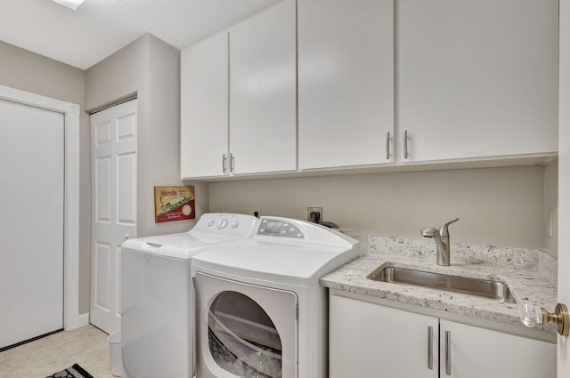 laundry room with cabinets, separate washer and dryer, and sink