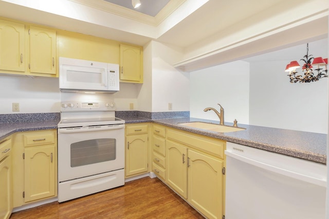 kitchen featuring dark hardwood / wood-style flooring, white appliances, crown molding, sink, and a chandelier