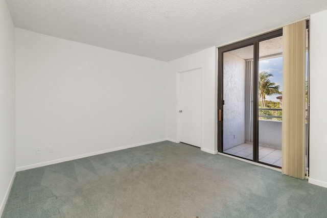 carpeted empty room with a textured ceiling