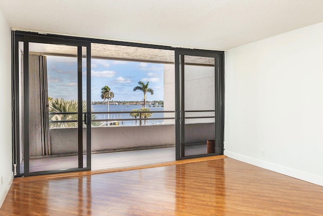 empty room featuring a water view and wood-type flooring