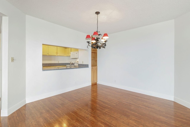 unfurnished living room with a notable chandelier, sink, wood-type flooring, and a textured ceiling