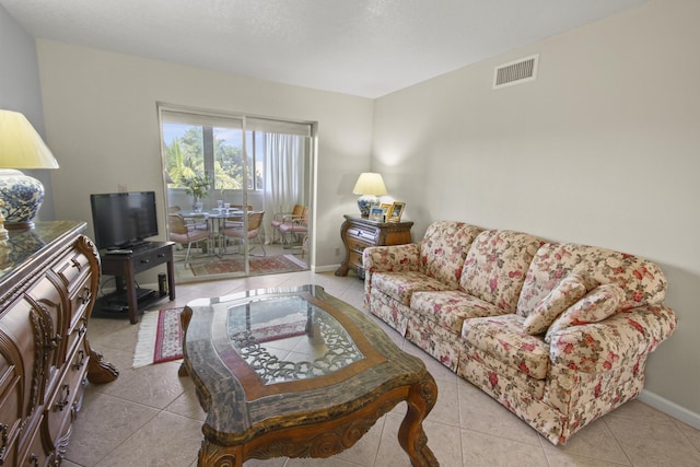 living area with visible vents, baseboards, and tile patterned flooring