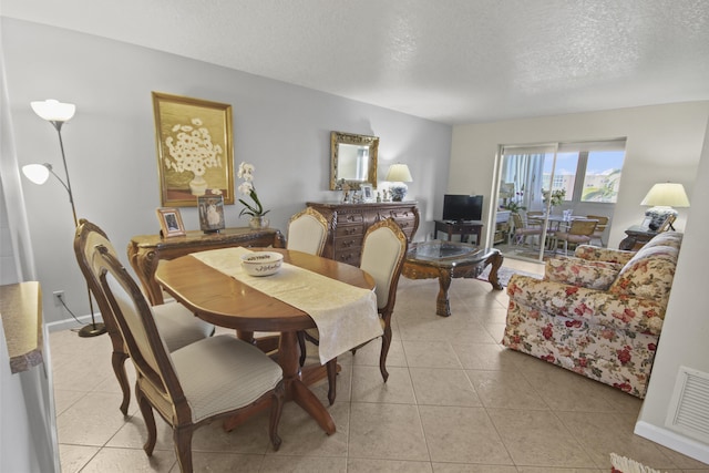 dining area featuring light tile patterned floors and a textured ceiling