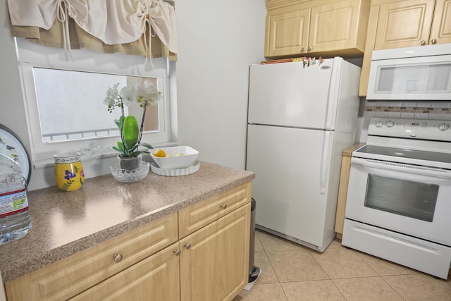 kitchen with dark countertops, backsplash, light brown cabinets, light tile patterned flooring, and white appliances