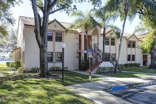 mediterranean / spanish home with a front lawn