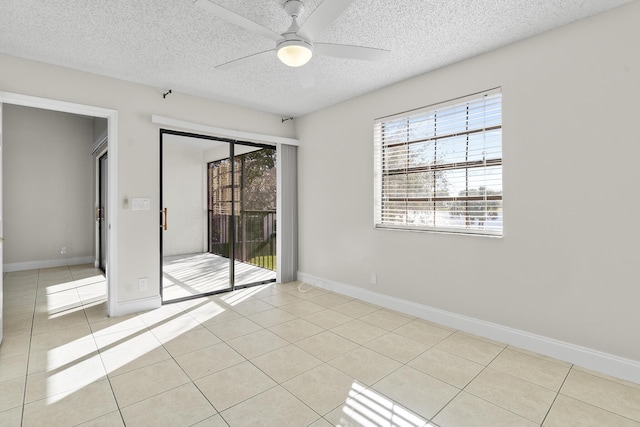 spare room featuring light tile patterned floors, a textured ceiling, and ceiling fan