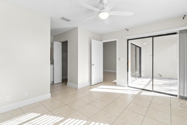 unfurnished bedroom with ceiling fan, a textured ceiling, and a closet