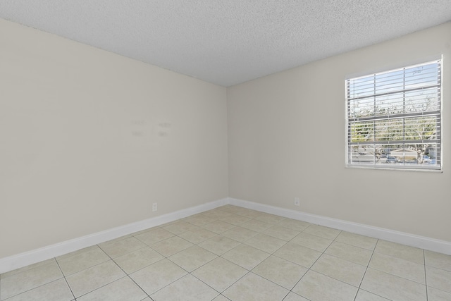 tiled spare room featuring a textured ceiling