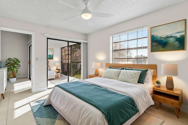 tiled bedroom with access to exterior, ceiling fan, and a textured ceiling