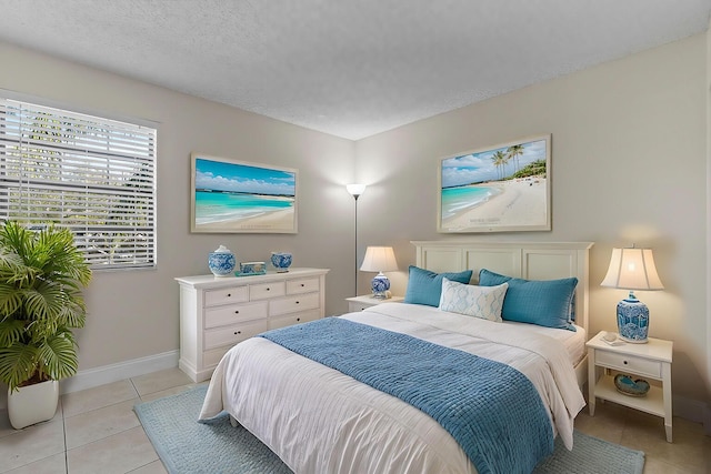 bedroom featuring light tile patterned floors and a textured ceiling