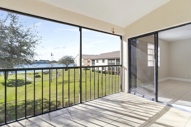 unfurnished sunroom with a water view and vaulted ceiling