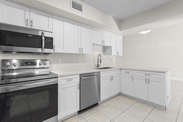 kitchen featuring white cabinetry, sink, stainless steel appliances, a textured ceiling, and light tile patterned floors