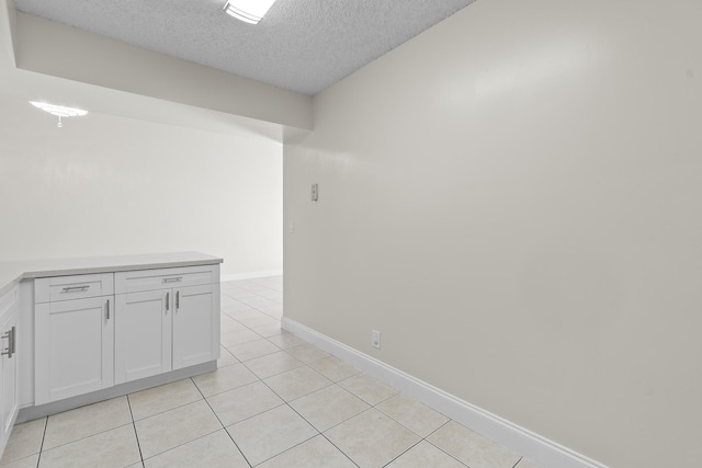 unfurnished room with light tile patterned floors and a textured ceiling