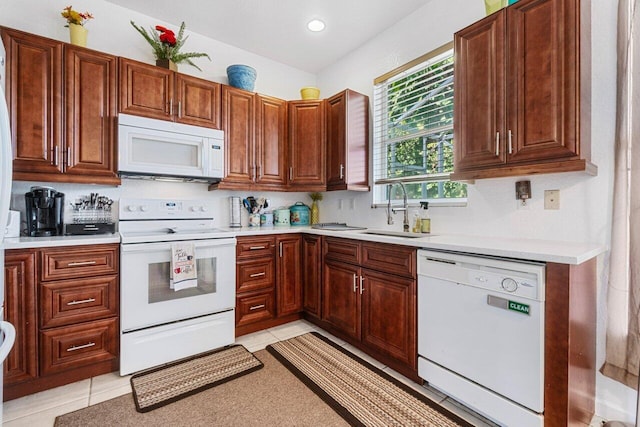 kitchen featuring sink, light tile patterned floors, and white appliances