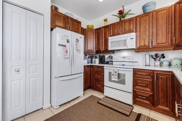 kitchen with white appliances and light tile patterned floors