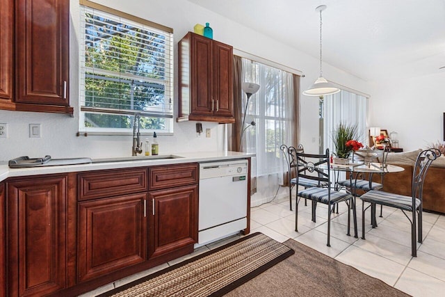 kitchen with dishwasher, sink, light tile patterned floors, and hanging light fixtures