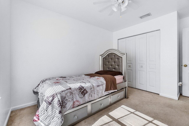 carpeted bedroom featuring a closet and ceiling fan