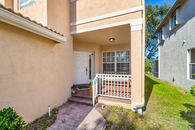 property entrance featuring a lawn