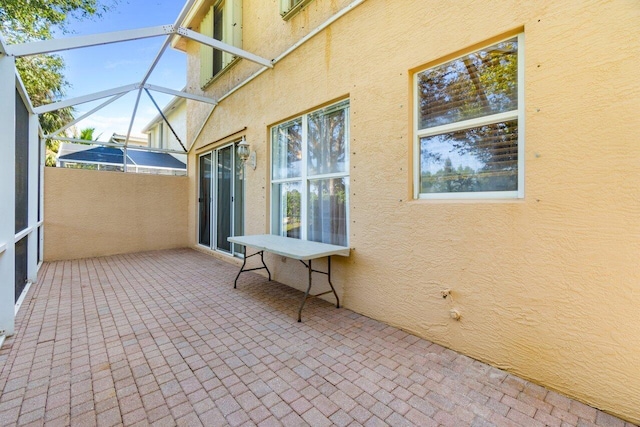 view of patio featuring a lanai