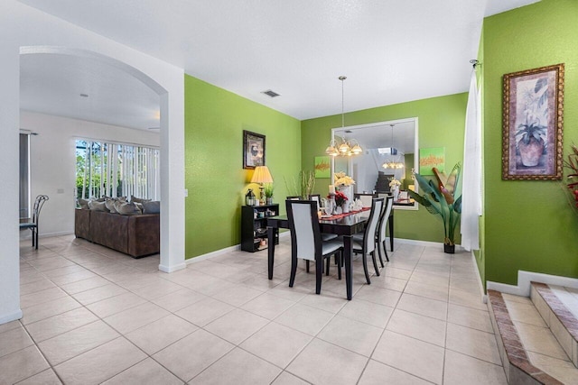 dining room with light tile patterned floors and a chandelier