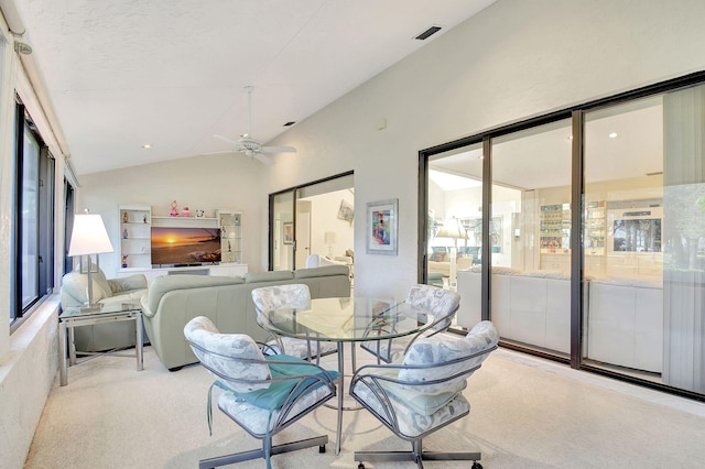 dining area featuring ceiling fan, light carpet, and lofted ceiling