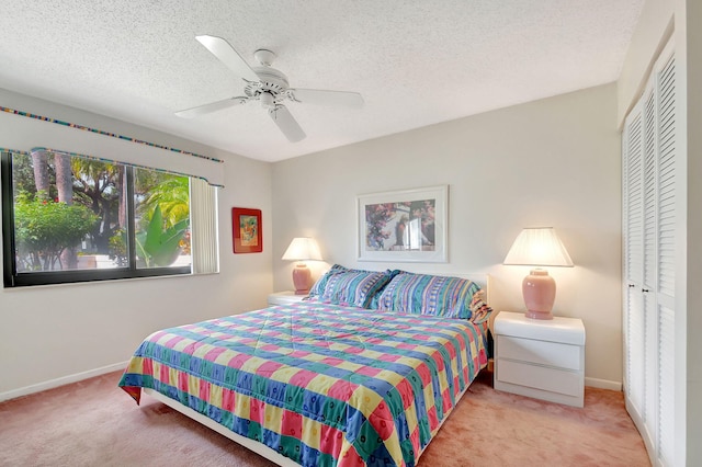 carpeted bedroom with a textured ceiling, a closet, and ceiling fan