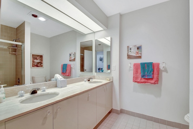 bathroom with tile patterned floors, vanity, a tile shower, and toilet