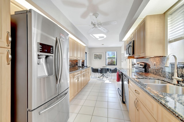 kitchen featuring light brown cabinetry, stainless steel appliances, tasteful backsplash, and sink